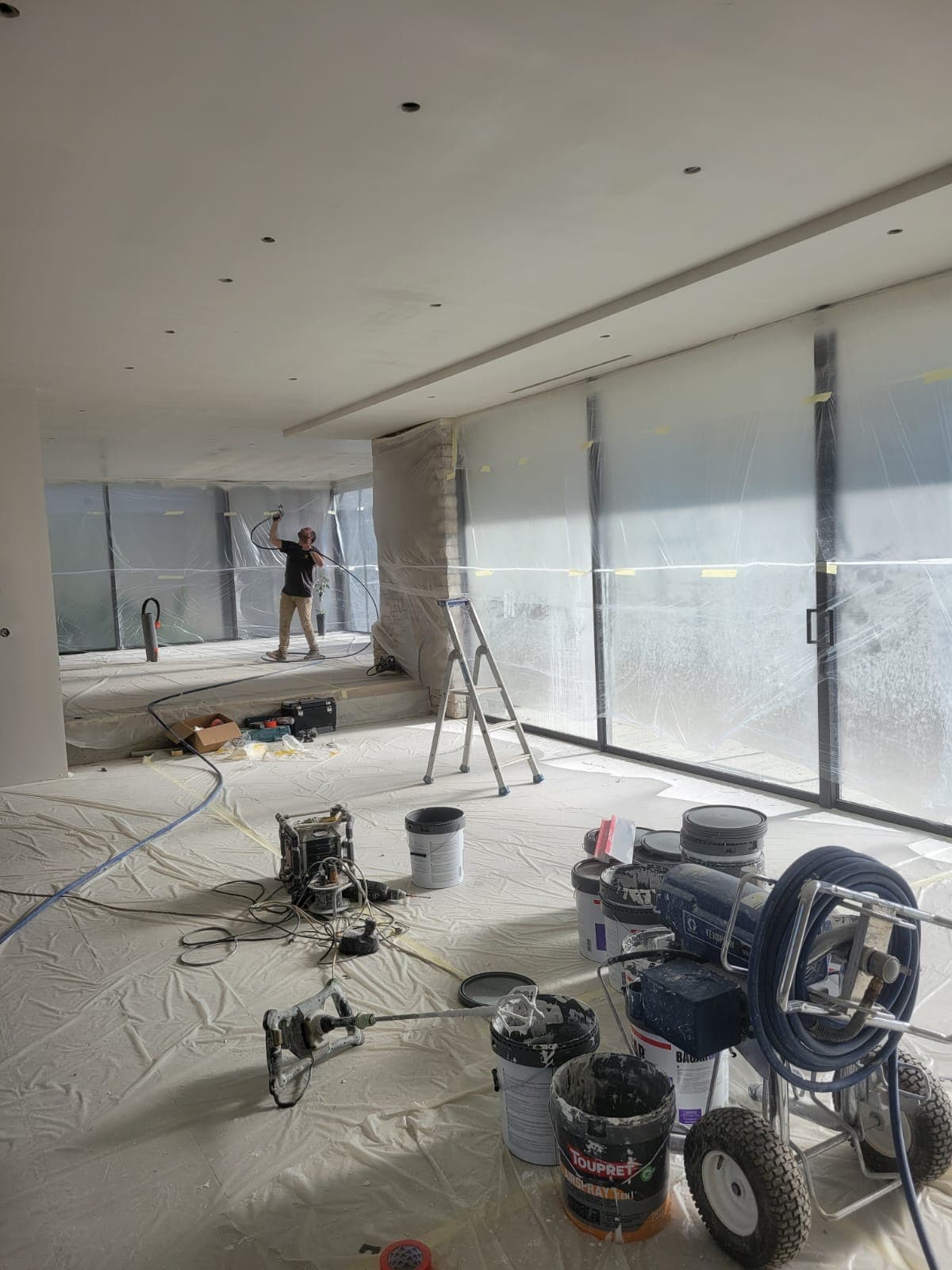 Peintre Belin Travaux appliquant la peinture au pistolet Airless sur un plafond près de Toulouse